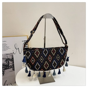 Close-up of bohemian woven crescent bag with colorful geometric patterns and tassels