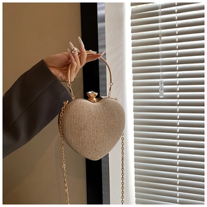 Detail of heart-shaped evening clutch with sparkling rhinestones and gold handle