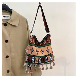 Detail of bohemian woven tote bag showing colorful tassel fringe and jacquard patterns