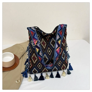 Detail of bohemian tote bag featuring ethnic geometric patterns and colorful tassels