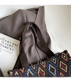 Detail view of ethnic geometric pattern tote bag with durable brown canvas handles