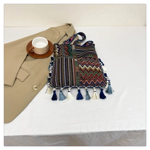 Detail of colorful Bohemian woven tote bag featuring ethnic patterns and fringe tassels