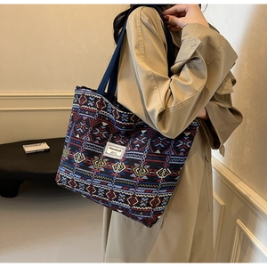 Detailed view of the colorful geometric pattern and fabric strap on a large canvas bag