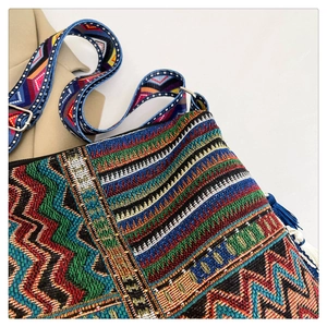 Detail view of Bohemian tote bag featuring colorful geometric weave and long fringe
