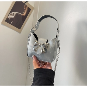 Detail view of silver mini bag with metallic bow and elegant chain strap for women