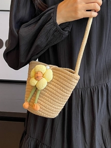 Handmade woven bucket bag in beige with yellow flower accent and sphere charms