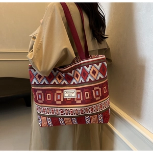 Detail of a large ethnic tote bag with geometric patterns and a woven shoulder strap