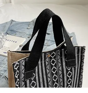 Detailed view of woven geometric patterns and durable black handles on a canvas tote bag