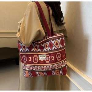 Close-up of geometric ethnic canvas tote bag with textured colorful woven patterns