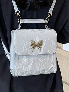 Sac à dos argenté à texture froissée avec papillon doré et bandoulière métallique