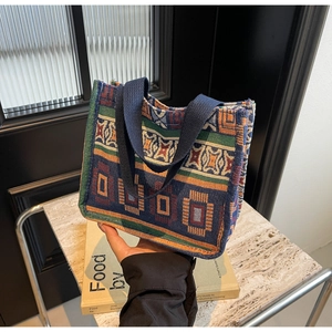 Detail of bohemian woven tote bag with colorful geometric patterns and canvas handles