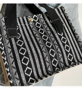 Detail of black and white geometric woven tote bag with durable reinforced handles