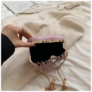 Detailed view of pink glitter clutch with crystal clasp and golden chain strap