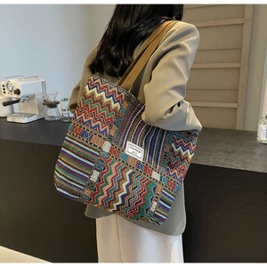 Detail of colorful zigzag woven canvas tote bag with wide brown shoulder strap