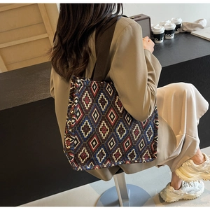 Close-up of bohemian geometric diamond pattern and wide brown strap on tote bag