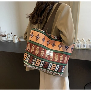 Detail view of ethnic weave patterns on a large canvas bucket bag with wide strap