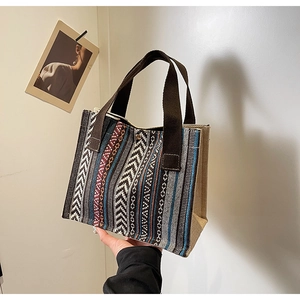 Detailed macro view of ethnic woven patterns and durable canvas handles on the tote bag