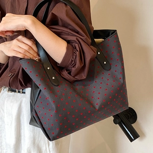 Spacious canvas tote bag with red heart polka dots and black leather studded handles