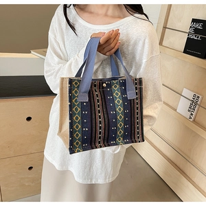 Detail of geometric ethnic tote bag with blue handles and golden magnetic closure