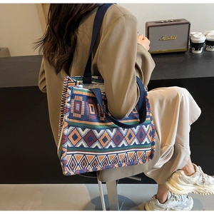 Macro detail of ethnic geometric jacquard fabric and sturdy navy blue handles on tote bag