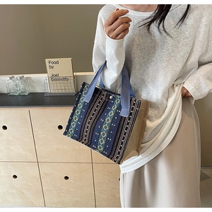 Detail of ethnic geometric patterned tote bag with light blue woven handles