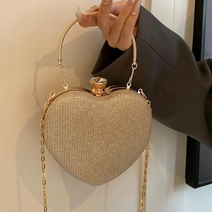 Elegant gold heart-shaped evening clutch bag with glitter finish and diamond clasp
