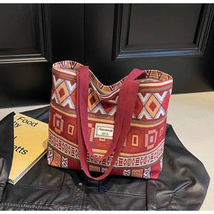 Detail of bohemian jacquard tote bag with ethnic red geometric patterns and brand label