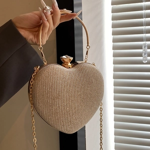 Elegant champagne gold heart-shaped clutch bag with glitter finish and rhinestone buckle