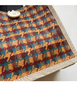 Detail of plaid linen tote bag showing orange weave texture and button closure