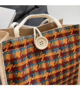 Detail view of linen lunch bag featuring colorful houndstooth pattern and button closure