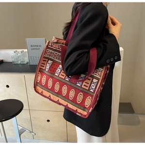 Close-up of Bohemian woven tote bag with geometric ethnic patterns on shoulder