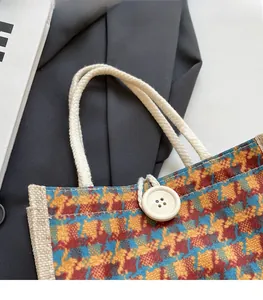 Close-up of woven houndstooth tote bag with cotton rope handle and white button detail