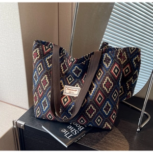 Macro detail of bohemian jacquard tote bag featuring geometric rhombus patterns