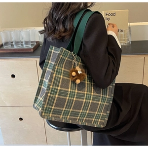 Dettaglio borsa tote in tela a quadri grande con spalline verdi e ciondolo peluche