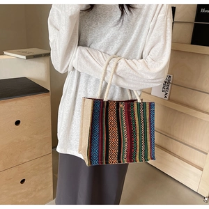 Detail of bohemian tote bag with geometric woven patterns and sturdy white cotton rope handles