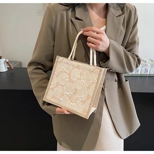 Detail of apricot square linen tote bag featuring embossed rose patterns and cotton rope handles