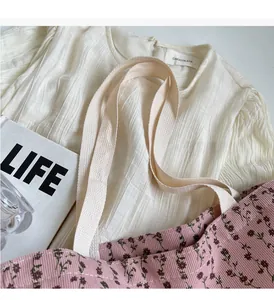 Gros plan d'un cabas en toile à fleurs roses avec tissu texturé et accessoires de mode