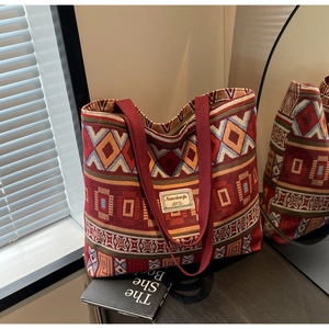 Detail of bohemian weave pattern on a large canvas bucket bag with wide strap