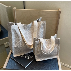 Gros plan sur le tissu floral gaufré crème des sacs cabas avec des anses épaisses