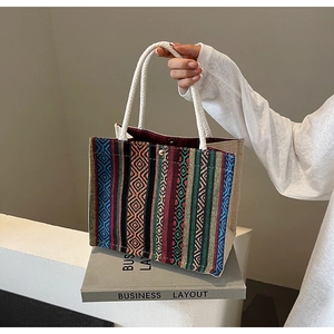 Close-up of geometric ethnic woven tote bag with cotton rope handles and snap button