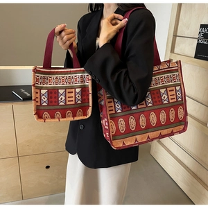 Detail of vintage ethnic knit tote bags with colorful geometric patterns in red tones
