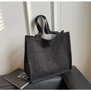 Vue détaillée du sac cabas noir avec texture jacquard florale et poignées en tissu