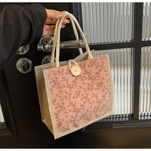 Dettaglio della borsa bento floreale con trama in velluto e manico in corda bianca