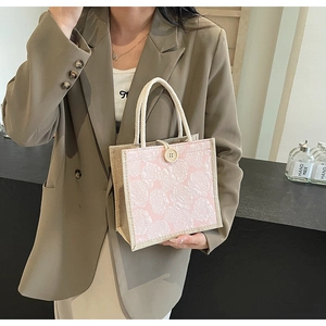 Detail of pink floral jacquard tote bag with linen handles and wooden button closure