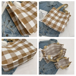 Detail view of brown checkered canvas tote bag with plush ball charm and inner lining