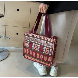 Detail of vintage bohemian tote bag with colorful geometric woven patterns and sturdy straps