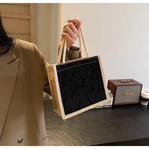 Close-up of linen tote bag with black rose pattern and cotton rope handle in retro setting