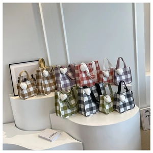 Detailed display of colorful plaid canvas tote bags with cute white heart plush charms