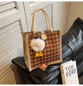 Detailed texture of linen tote bag featuring orange houndstooth pattern and plush charm