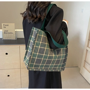 Dettaglio del motivo scozzese retrò e del cinturino in tessuto verde sulla borsa tote